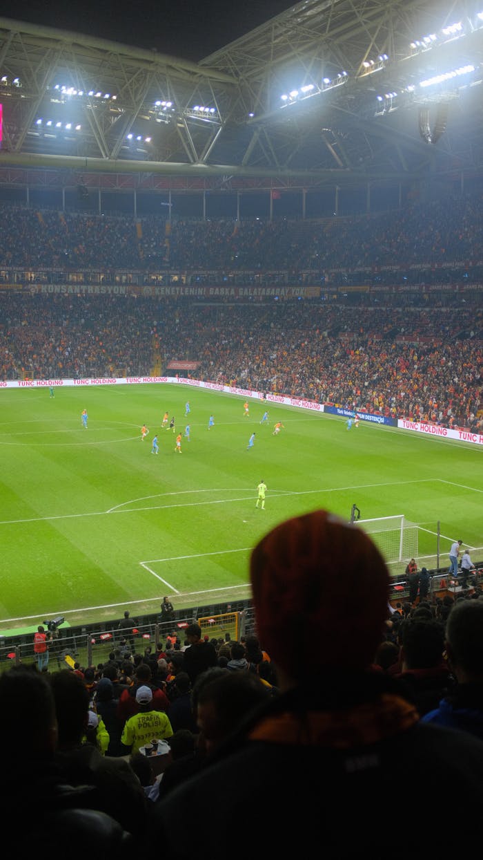 Services Thrilling soccer match at a packed Istanbul stadium with vibrant crowd and atmospheric lighting.